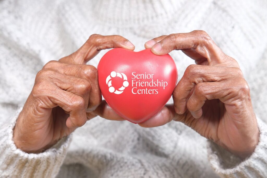 senior women holding red heart close up